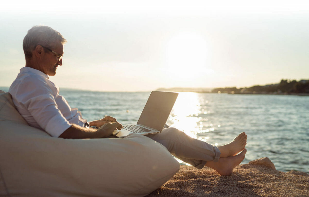 Man with laptop on beach